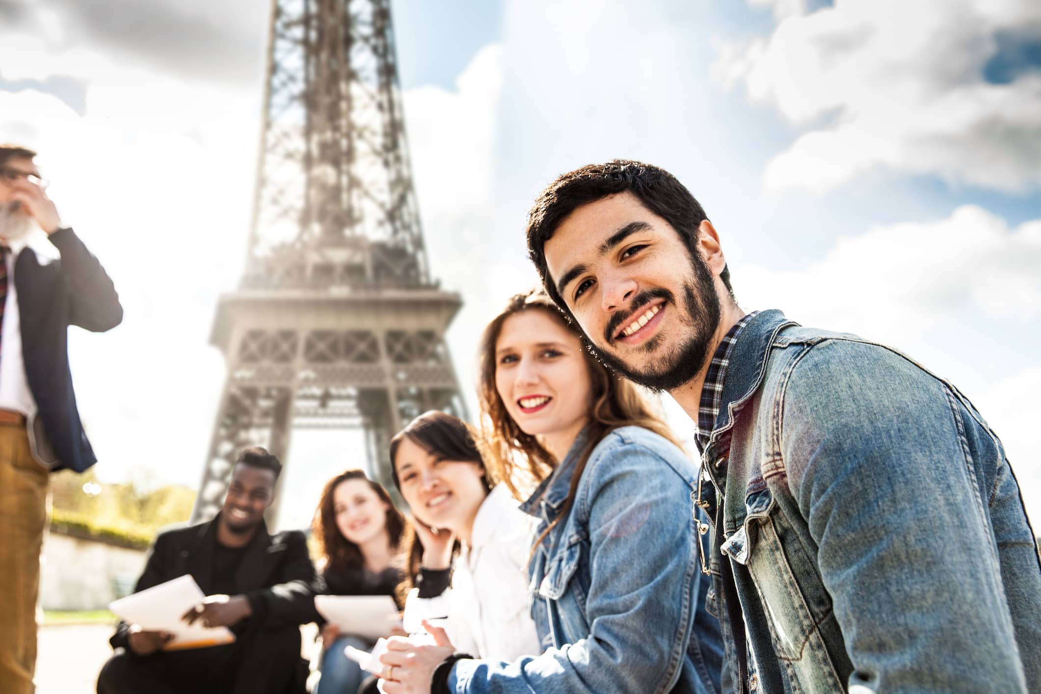 Image d'illustration : représentation de la diversité de la jeunesse devant la Tour Eiffel.