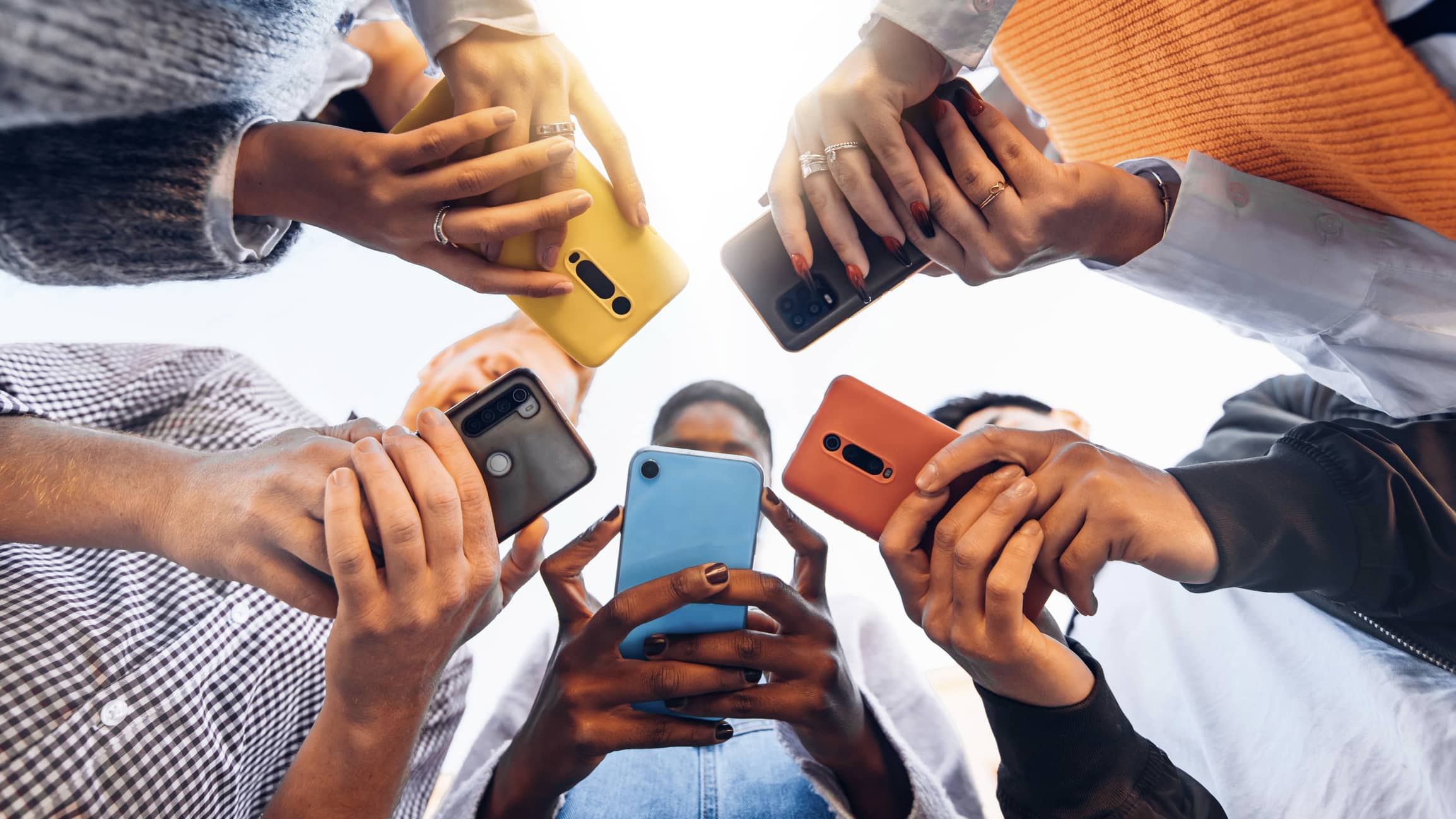 Image d'illustration représentant plusieurs personnes qui consultent leur téléphone portable.
